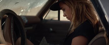 Movie still from “The Bad Batch” (2016), directed by Ana Lily Amirpour – A woman sitting in the driver's seat of a car; Close Up shot, Over the shoulder angle