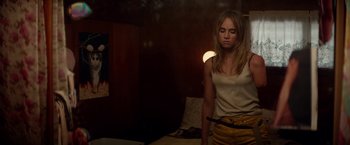 Movie still from “The Bad Batch” (2016), directed by Ana Lily Amirpour – A woman standing in a dark room with her hands on her hips; Medium shot, High angle