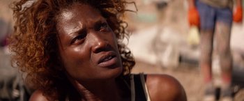 Movie still from “The Bad Batch” (2016), directed by Ana Lily Amirpour – A person with curly brown hair; Close Up shot, High angle