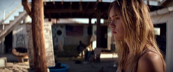 Movie still from “The Bad Batch” (2016), directed by Ana Lily Amirpour – A woman with long blonde hair looking to her left; Close Up shot, Over the shoulder angle
