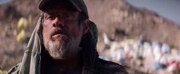 Movie still from “The Bad Batch” (2016), directed by Ana Lily Amirpour – A person with long hair and a beard; Close Up shot, Low angle