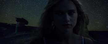 Movie still from “The Bad Batch” (2016), directed by Ana Lily Amirpour – A beautiful woman standing in front of the night sky; Close Up shot, Low angle