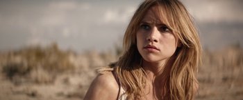 Movie still from “The Bad Batch” (2016), directed by Ana Lily Amirpour – A person with long blonde hair; Close Up shot, Over the shoulder angle