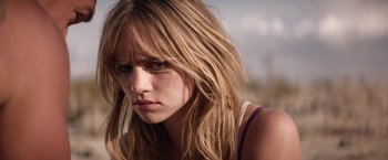 Movie still from “The Bad Batch” (2016), directed by Ana Lily Amirpour – A person with long blonde hair; Close Up shot, Over the shoulder angle