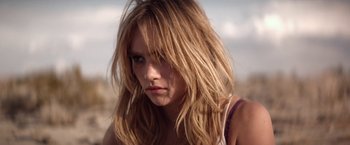 Movie still from “The Bad Batch” (2016), directed by Ana Lily Amirpour – A person with long blonde hair; Close Up shot, Low angle