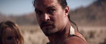 Movie still from “The Bad Batch” (2016), directed by Ana Lily Amirpour – A person with long hair; Close Up shot, Over the shoulder angle