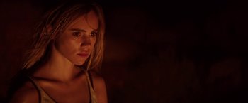 Movie still from “The Bad Batch” (2016), directed by Ana Lily Amirpour – A beautiful young woman with long blonde hair wearing a yellow tie; Close Up shot, Low angle