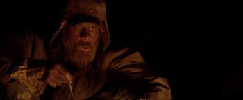 Movie still from “The Bad Batch” (2016), directed by Ana Lily Amirpour – A man with a long beard wearing a hood; Close Up shot, Low angle