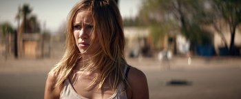 Movie still from “The Bad Batch” (2016), directed by Ana Lily Amirpour – A beautiful young woman with long , blonde hair; Close Up shot, Over the shoulder angle