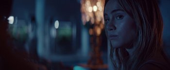 Movie still from “The Bad Batch” (2016), directed by Ana Lily Amirpour – A woman's face in front of lights; Close Up shot, Over the shoulder angle
