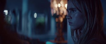 Movie still from “The Bad Batch” (2016), directed by Ana Lily Amirpour – A young woman is staring into the distance in a dark room; Close Up shot, Low angle