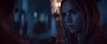 Movie still from “The Bad Batch” (2016), directed by Ana Lily Amirpour – A woman is holding a piece of food in her hand; Close Up shot, Over the shoulder angle