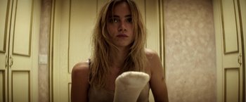 Movie still from “The Bad Batch” (2016), directed by Ana Lily Amirpour – A woman with long blonde hair is looking at the camera; Close Up shot, Low angle