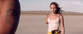 Movie still from “The Bad Batch” (2016), directed by Ana Lily Amirpour – A woman standing in the middle of an empty field; Medium shot, Low angle