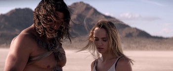 Movie still from “The Bad Batch” (2016), directed by Ana Lily Amirpour – Two people standing in the sand near a mountain; Close Up shot, Over the shoulder angle