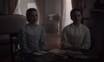 Movie still from “The Beguiled” (2017), directed by Sofia Coppola – Two young women sitting at a table in a living room; Medium shot, Over the shoulder angle
