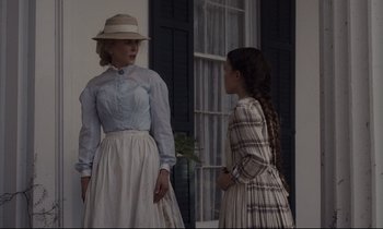 Movie still from “The Beguiled” (2017), directed by Sofia Coppola – A woman and a young girl standing next to each other in front of a window; Medium shot, Low angle