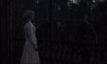 Movie still from “The Beguiled” (2017), directed by Sofia Coppola – A woman standing in front of a metal fence; Wide shot, Over the shoulder angle