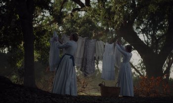 Movie still from “The Beguiled” (2017), directed by Sofia Coppola – Two women hanging clothes on a clothesline; Wide shot, Low angle