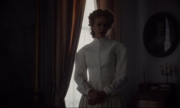 Movie still from “The Beguiled” (2017), directed by Sofia Coppola – A woman standing in front of a window wearing a white dress; Medium shot, Low angle