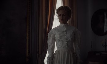 Movie still from “The Beguiled” (2017), directed by Sofia Coppola – A woman standing in front of a window wearing a white dress; Medium shot, Low angle