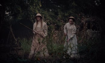 Movie still from “The Beguiled” (2017), directed by Sofia Coppola – A couple of people that are standing in the grass; Medium shot, High angle