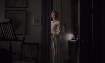 Movie still from “The Beguiled” (2017), directed by Sofia Coppola – A woman in a white dress standing in front of a window; Medium shot, Over the shoulder angle
