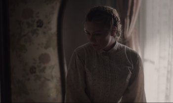 Movie still from “The Beguiled” (2017), directed by Sofia Coppola – A woman in a white shirt is standing by a window; Medium shot, Over the shoulder angle