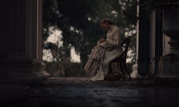 Movie still from “The Beguiled” (2017), directed by Sofia Coppola – A woman sitting on a chair holding a blanket; Wide shot, Over the shoulder angle