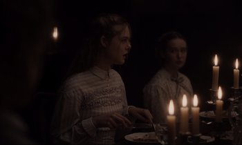 Movie still from “The Beguiled” (2017), directed by Sofia Coppola – Two young women standing next to each other in front of candles; Medium shot, Over the shoulder angle