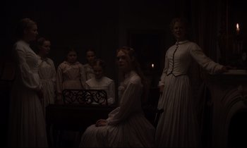 Movie still from “The Beguiled” (2017), directed by Sofia Coppola – A group of women in white dresses standing next to each other in a dark room; Medium shot, Low angle