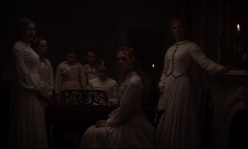 Movie still from “The Beguiled” (2017), directed by Sofia Coppola – A group of women in white dresses in a dark room; Medium shot, Low angle
