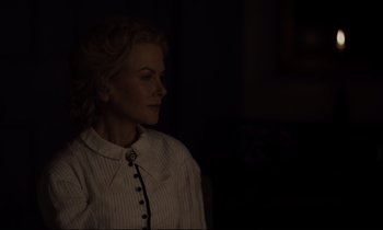Movie still from “The Beguiled” (2017), directed by Sofia Coppola – A woman in a white shirt is standing in a dark room; Close Up shot, Over the shoulder angle