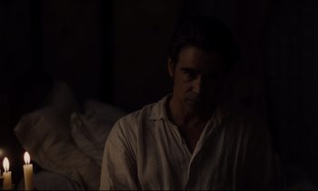 Movie still from “The Beguiled” (2017), directed by Sofia Coppola – A man sitting in a dark room looking at the camera; Medium shot, Over the shoulder angle