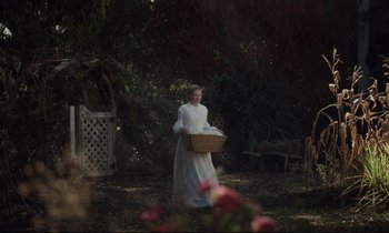 Movie still from “The Beguiled” (2017), directed by Sofia Coppola – A woman in a white dress holding a wicker basket; Wide shot, High angle