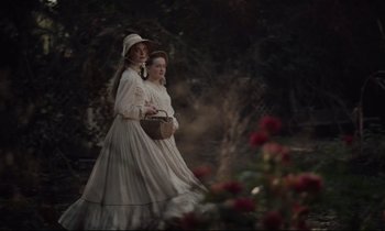 Movie still from “The Beguiled” (2017), directed by Sofia Coppola – Two women in white dresses and a white hat; Wide shot, High angle