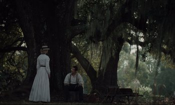 Movie still from “The Beguiled” (2017), directed by Sofia Coppola – A man and a woman sitting in front of a tree; Wide shot, Over the shoulder angle