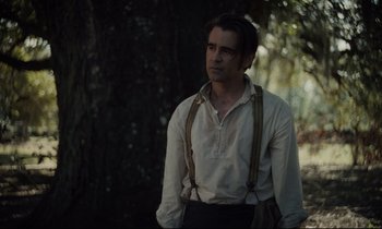 Movie still from “The Beguiled” (2017), directed by Sofia Coppola – A man in a white shirt and suspenders standing in front of a tree; Medium shot, Over the shoulder angle