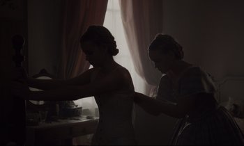 Movie still from “The Beguiled” (2017), directed by Sofia Coppola – A woman in a white dress and a woman in a gray shirt; Medium shot, Low angle