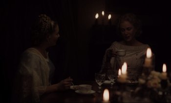 Movie still from “The Beguiled” (2017), directed by Sofia Coppola – Two women are sitting at a table drinking tea; Medium shot, Over the shoulder angle