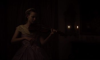 Movie still from “The Beguiled” (2017), directed by Sofia Coppola – A girl in a dress is playing a violin; Medium shot, Low angle