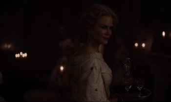 Movie still from “The Beguiled” (2017), directed by Sofia Coppola – A woman in a white dress is holding a candle; Medium shot, Over the shoulder angle