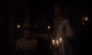 Movie still from “The Beguiled” (2017), directed by Sofia Coppola – A woman in a white dress holding a lit candle; Medium shot, Low angle