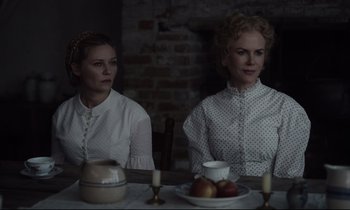 Movie still from “The Beguiled” (2017), directed by Sofia Coppola – Two women sitting at a table with a bowl of apples; Medium shot, Over the shoulder angle