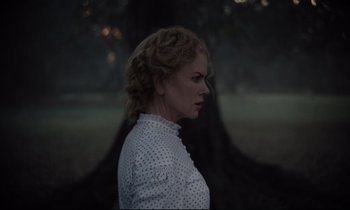 Movie still from “The Beguiled” (2017), directed by Sofia Coppola – A woman in a polka dot shirt standing in front of a tree; Close Up shot, Over the shoulder angle
