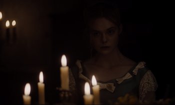 Movie still from “The Beguiled” (2017), directed by Sofia Coppola – A woman standing in front of a group of lit candles; Medium shot, Over the shoulder angle