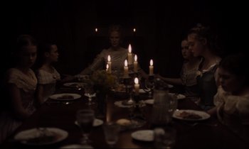 Movie still from “The Beguiled” (2017), directed by Sofia Coppola – A group of people sitting around a table with candles; Medium shot, High angle