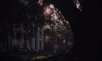 Movie still from “The Beguiled” (2017), directed by Sofia Coppola – A tree in front of a building and a tree in the background; Extreme Wide shot, Low angle