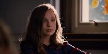 Movie still from “The Book of Henry” (2017), directed by Colin Trevorrow – A young girl with long hair sitting in a room; Close Up shot, Over the shoulder angle