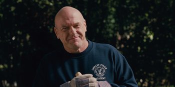 Movie still from “The Book of Henry” (2017), directed by Colin Trevorrow – A bald man wearing a navy blue shirt is eating a hot dog; Close Up shot, Low angle